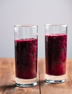 two clear glasses filled with blueberry slush