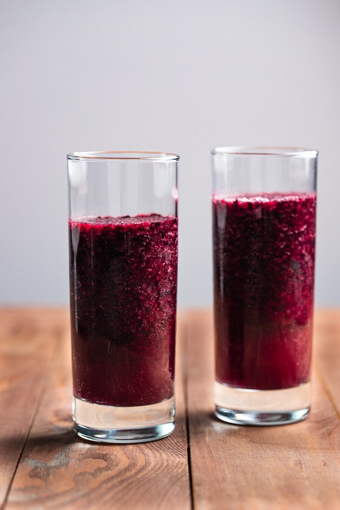 two clear glasses filled with blueberry slush