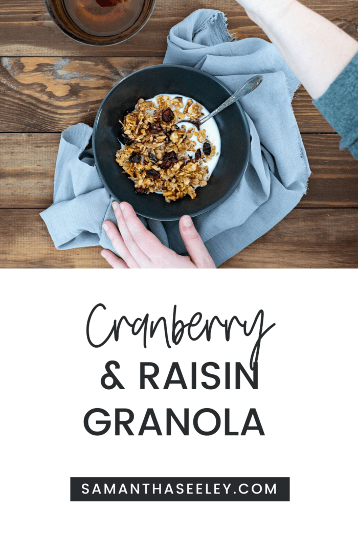 granola in a bowl of milk with hands reaching for honey